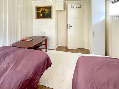 a room with two beds and a table and a door at Two-Bedroom Holiday home in Laupstad 4 in Vestpollen