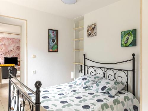 a bedroom with a bed with a black frame at Sunlit Garden Escape Normandy in Isigny-sur-Mer