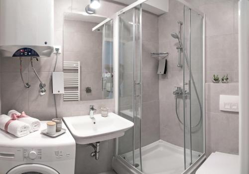 uma casa de banho com um chuveiro, um lavatório e um WC. em Apartments with a parking space Omis - 17677 em Omiš
