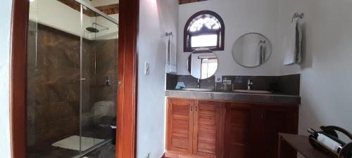a bathroom with a shower and a sink and a mirror at Casa Hotel San Pedro in Villa de Leyva