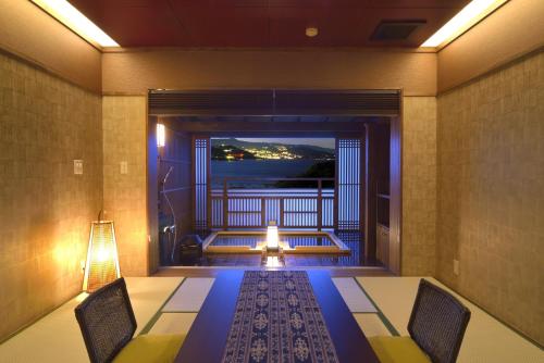 a room with a balcony with a table and chairs at Uminohana in Atami