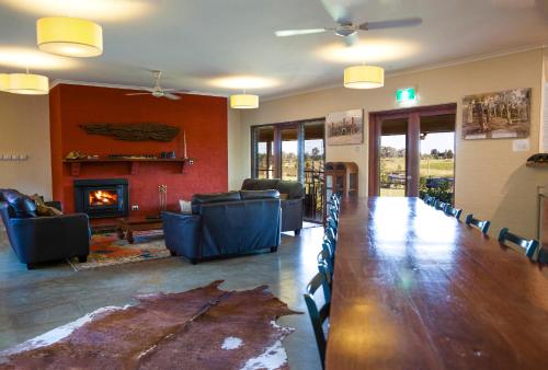 a living room with a long table and a fireplace at Burncroft Guesthouse in Lovedale