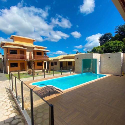 une villa avec une piscine en face d'une maison dans l'établissement Pousada Cipó Cana, à Santana do Riacho