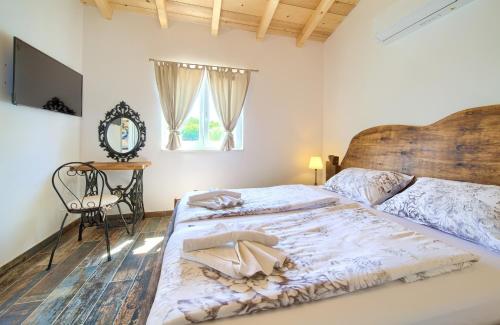 een slaapkamer met een groot bed met een houten hoofdeinde bij Family friendly house with a swimming pool Vrh, Krk - 17760 in Vrh