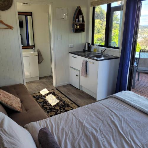 a room with a bed and a kitchen with a sink at Wild Days Accommodation in Palm Beach