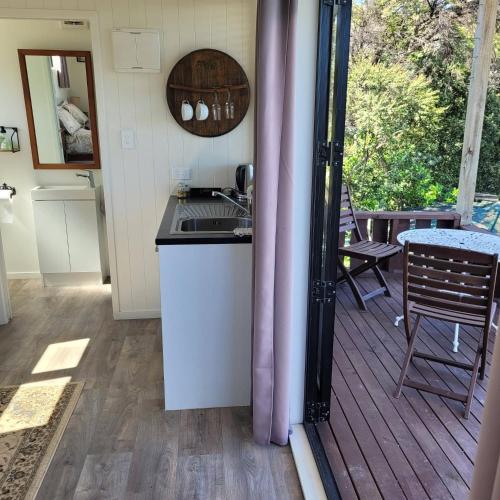 a kitchen and a deck with a table and chairs at Wild Days Accommodation in Palm Beach
