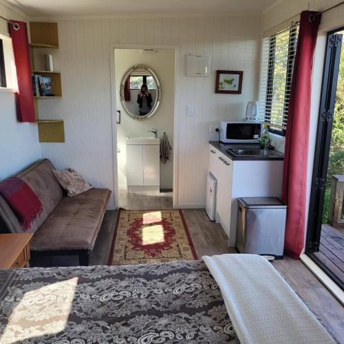 a small living room with a couch and a kitchen at Wild Days Accommodation in Palm Beach