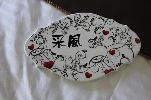 a white plate with a pattern of hearts on it at Sunny Breeze Garden Homestay in Jiali