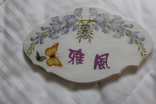 a plate with purple flowers and butterflies on it at Sunny Breeze Garden Homestay in Jiali