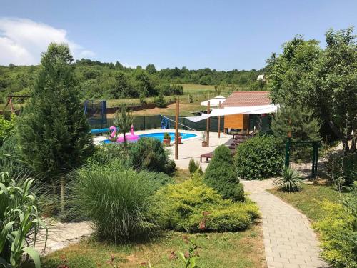 une maison avec une piscine dans un jardin dans l'établissement Family friendly apartments with a swimming pool Ostarski Stanovi, Plitvice - 17806, à Rakovica