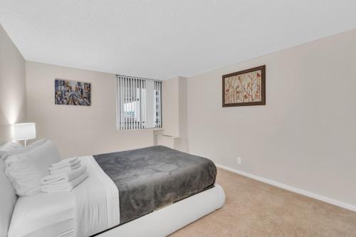 a white bedroom with a bed and a window at Arlington 2BR 2Ba Apartment in Crystal City apts in Arlington