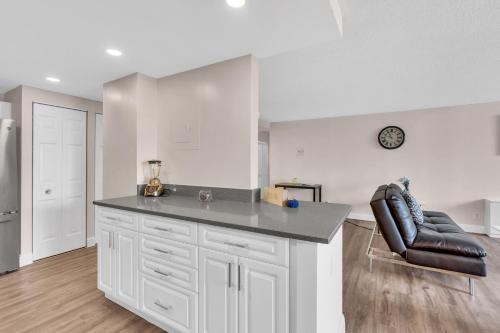 a white kitchen with a counter and a chair at Arlington 2BR 2Ba Apartment in Crystal City apts in Arlington