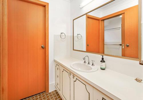 een badkamer met een wastafel en een spiegel bij The Haven in Shoalhaven Heads