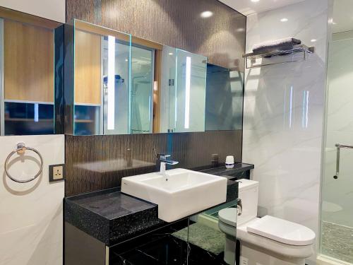 a bathroom with a sink and a toilet and a mirror at Walking Street Condo Beautiful 1 king bedroom in Angeles