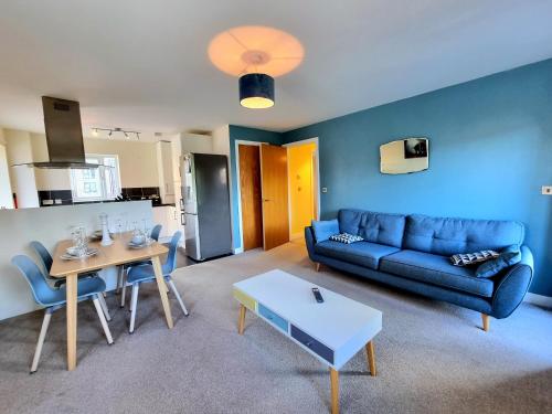 een woonkamer met een blauwe bank en een tafel bij Luxury 2-Bedroom Service Apartment with Balcony in Manchester