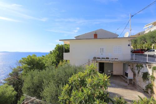 une maison blanche avec vue sur l'océan dans l'établissement Apartments by the sea Sumpetar, Omis - 17895, à Sumpetar