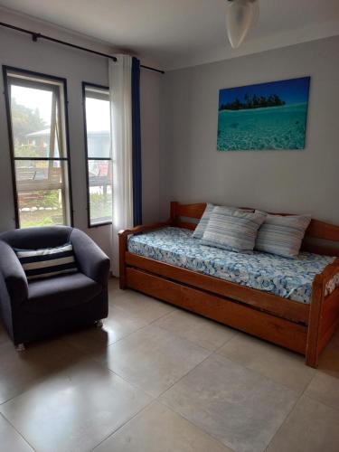 1 dormitorio con 1 cama y 1 silla en Residencial Maria Vitoria, en Florianópolis