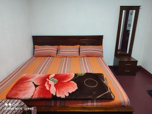 a bedroom with a bed with a flower on it at GREENISH INN (ROOMS) in Nanu Oya