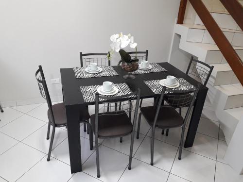 a black dining room table with black chairs at Triplex ideal para grupos. Acomoda mais de 20. in Curitiba