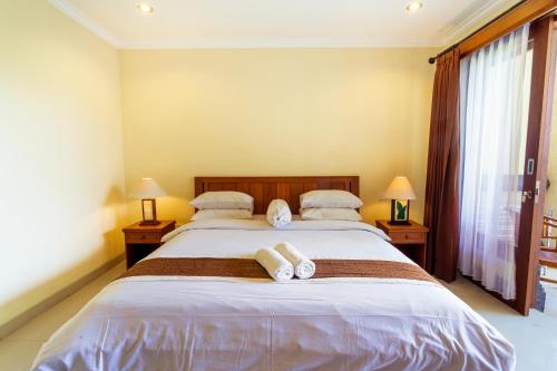 a bedroom with a large bed with towels on it at Sakura Guest House in Canggu