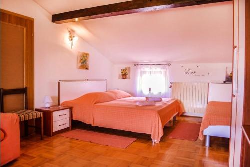ブゼトにあるRooms with a parking space Buzet, Central Istria - Sredisnja Istra - 17835のベッドルーム1室(オレンジ色のベッドカバー付)、窓が備わります。