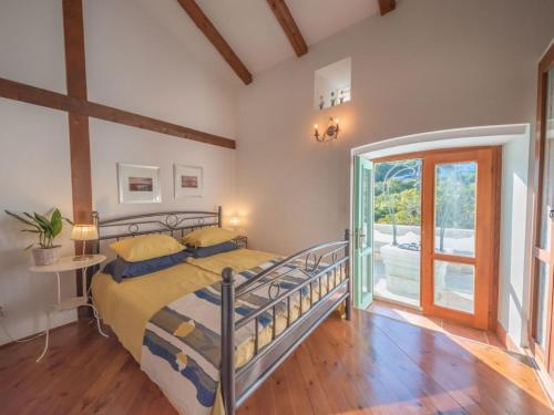 a bedroom with a bed and a glass door at Family friendly house with a swimming pool Zagore, Opatija - 17924 in Mošćenička Draga