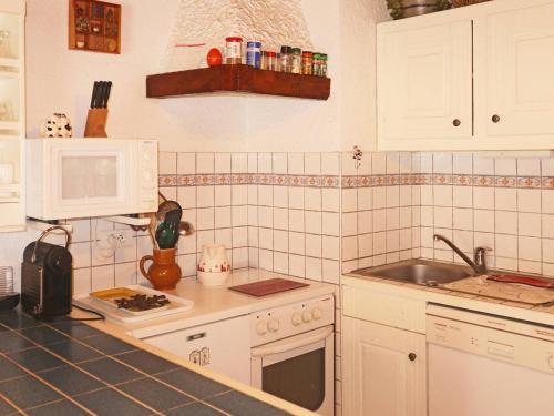une cuisine avec un évier et un micro-ondes dans l'établissement Studio pour 4 pers, skis aux pieds, garderie proche - FR-1-322-486, aux Orres