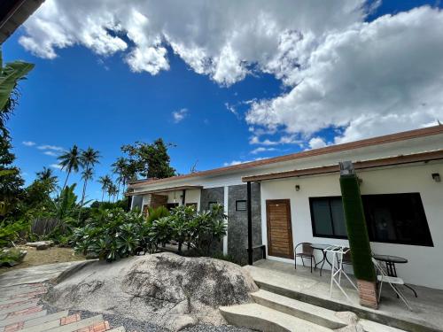 a house with a rock in front of it at Field-D House in Koh Tao