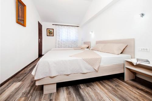 sypialnia z dużym łóżkiem i drewnianą podłogą w obiekcie Apartments by the sea Rovinj - 17935 w Rovinj