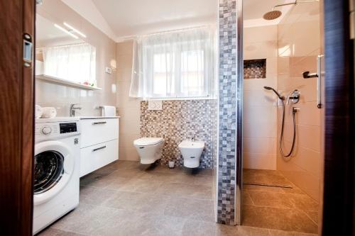 een badkamer met een wasmachine en een toilet bij Apartments by the sea Rovinj - 17935 in Rovinj