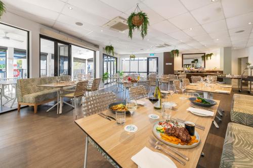 a restaurant with tables and chairs with food on them at Coral Cay Resort in Mackay