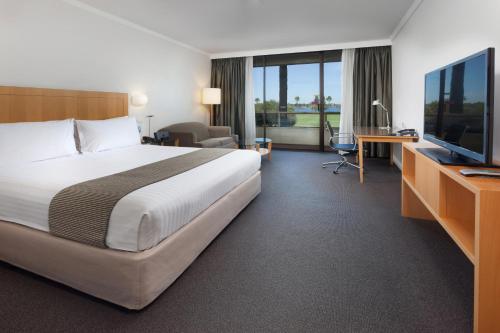 een hotelkamer met een groot bed en een televisie bij Crowne Plaza Perth, an IHG Hotel in Perth