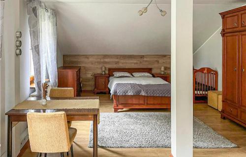um quarto com uma cama, uma mesa e um berço em Beautiful Home In Slawno With 3 Bedrooms And Wifi em Sławno