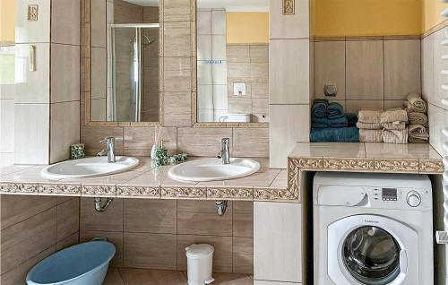 uma casa de banho com 2 lavatórios e uma máquina de lavar roupa em Beautiful Home In Slawno With 3 Bedrooms And Wifi em Sławno