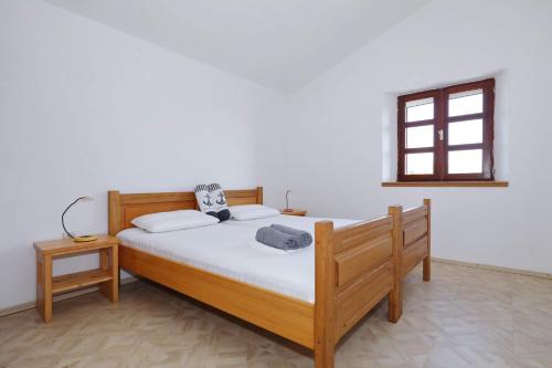 um quarto com uma cama com lençóis brancos e uma janela em Secluded fisherman's cottage Ravna Sika, Kornati - 17947 em Murter