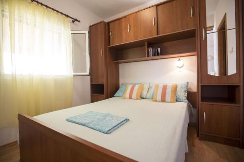 a bedroom with a large bed with wooden cabinets at Apartments by the sea Vis - 17960 in Vis