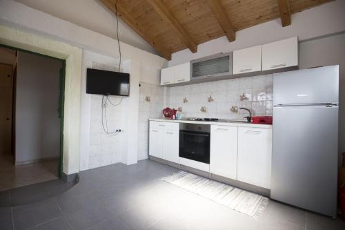 a kitchen with a white refrigerator and a tv at Apartments by the sea Vis - 17960 in Vis