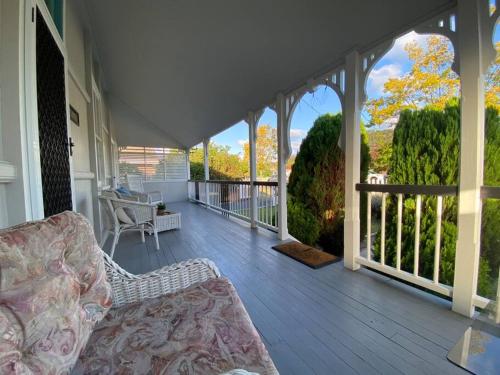 a screened in porch with a couch and chairs on it at Finney Cottage in Stanthorpe