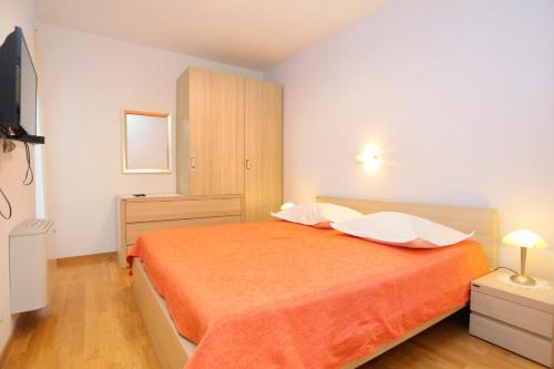 una camera con un letto e una coperta arancione di Family friendly apartments with a swimming pool Klis, Split - 17987 a Klis