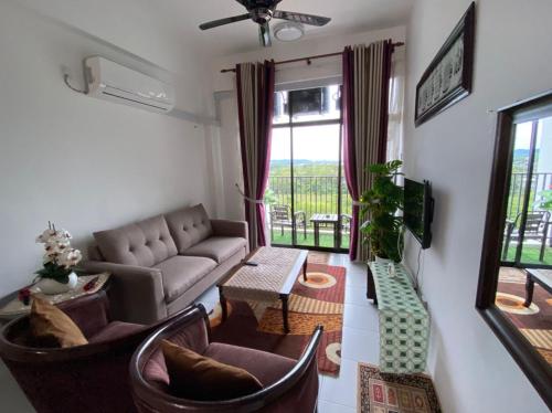 sala de estar con sofá y TV en Maz Stayhouse en Alor Setar