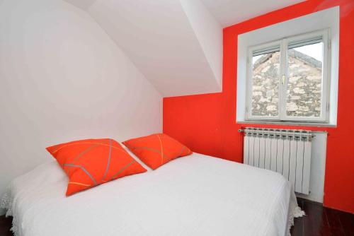 ein rot-weißes Schlafzimmer mit einem Bett und einem Fenster in der Unterkunft Holiday house with WiFi Zlarin - 17998 in Zlarin