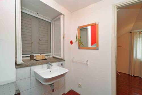 a bathroom with a sink and a mirror at Holiday house with WiFi Zlarin - 17998 in Zlarin