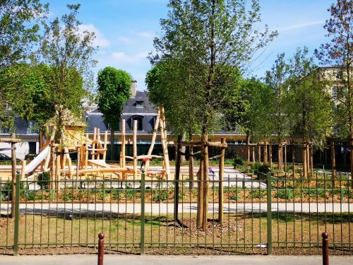 um parque infantil num parque com uma cerca em Les Carrés em Versailles