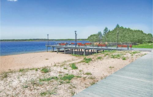 un quai sur une plage à côté d'un plan d'eau dans l'établissement Holiday Home Nowe Warpno Szczecinska, à Karszno