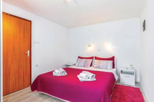 ein Schlafzimmer mit einem roten Bett mit Handtüchern darauf in der Unterkunft Apartments for families with children Krasica, Rijeka - 18032 in Krasica