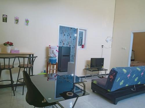 ein Wohnzimmer mit einem TV und einem Tisch in der Unterkunft The Garden Homestay Syariah dekat Batu, pintu tol, UB, UMM in Blimbing