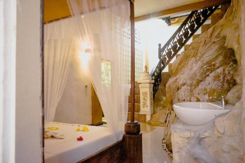 a bathroom with a tub and a sink in a room at Jungle Inn Bukit lawang in Bukit Lawang