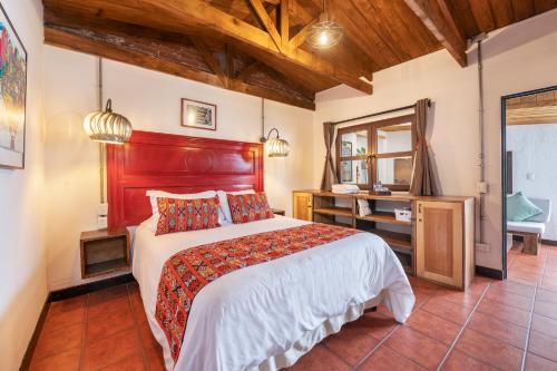 a bedroom with a large bed and a mirror at Barbara's Boutique Hostel in Antigua Guatemala