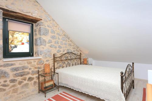 1 dormitorio con cama y pared de piedra en Holiday house with a parking space Zivogisce - Strnj - Zivogosce - Strnj, Makarska - 18025 en Živogošće