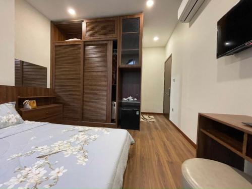 una camera da letto con un letto, una scrivania e una televisione di Golden Lotus Homestay a Phu Quoc